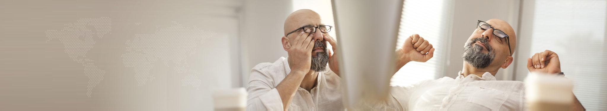 Müder Mann mit Bart, Brille und Glatze